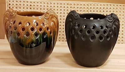 Sort og gul/grøn krukke med gennembrudt mønster øverst